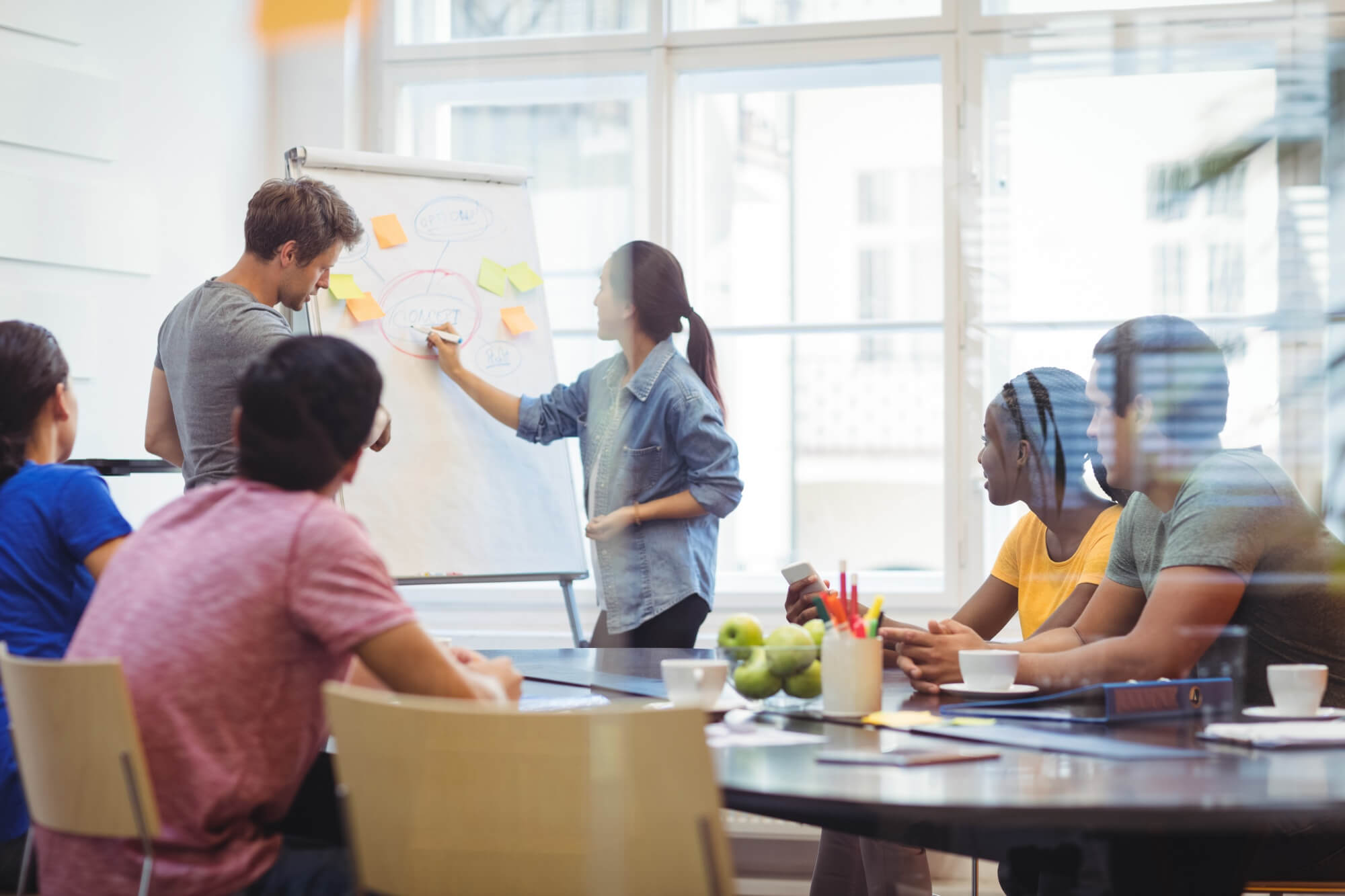 business-executives-discussing-with-their-colleagues-whiteboard